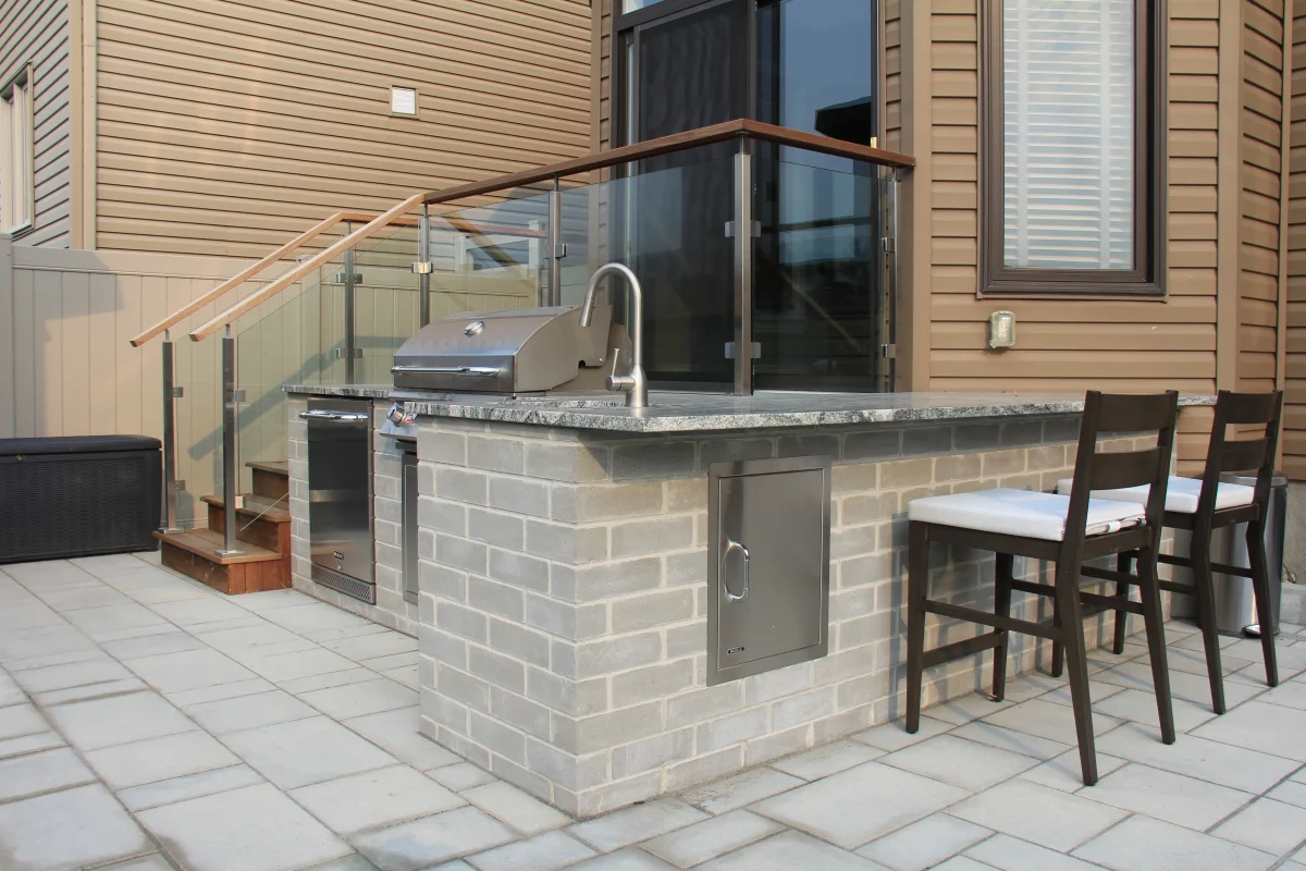 Mickelberry built-in grill island, stone counter and glass-railed deck