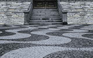 View of the entrance of a home designed entirely of interlocking stone in various colours and patterns