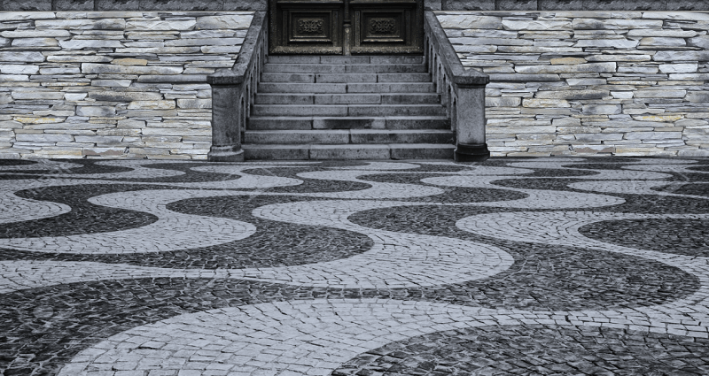 View of the entrance of a home designed entirely of interlocking stone in various colours and patterns