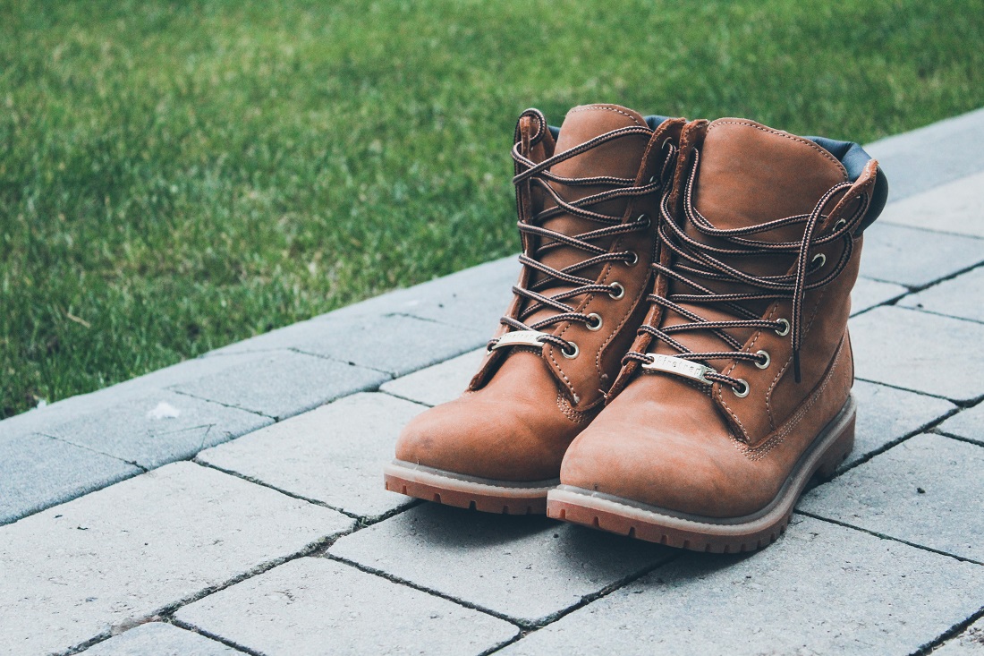 construction boots on an interlock stone pathway next to a manicured lawn
