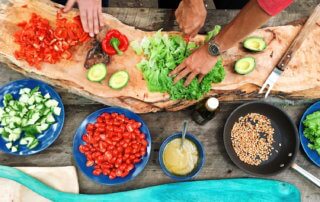 People chopping vegetables in outdoor kitchen