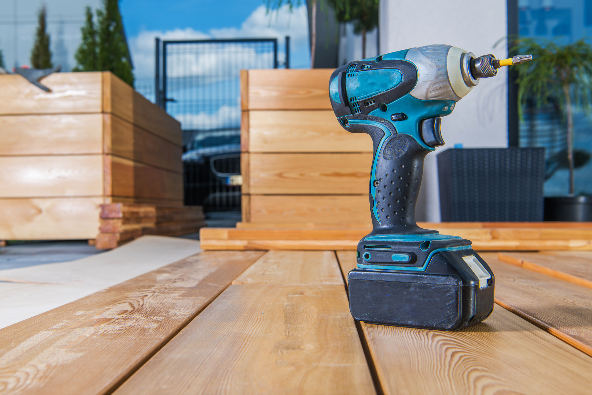 hand drill on the floor of new wood flooring next to new plant boxes