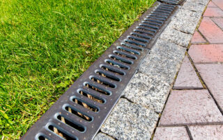 Example of a drainage system along the interlock and grass